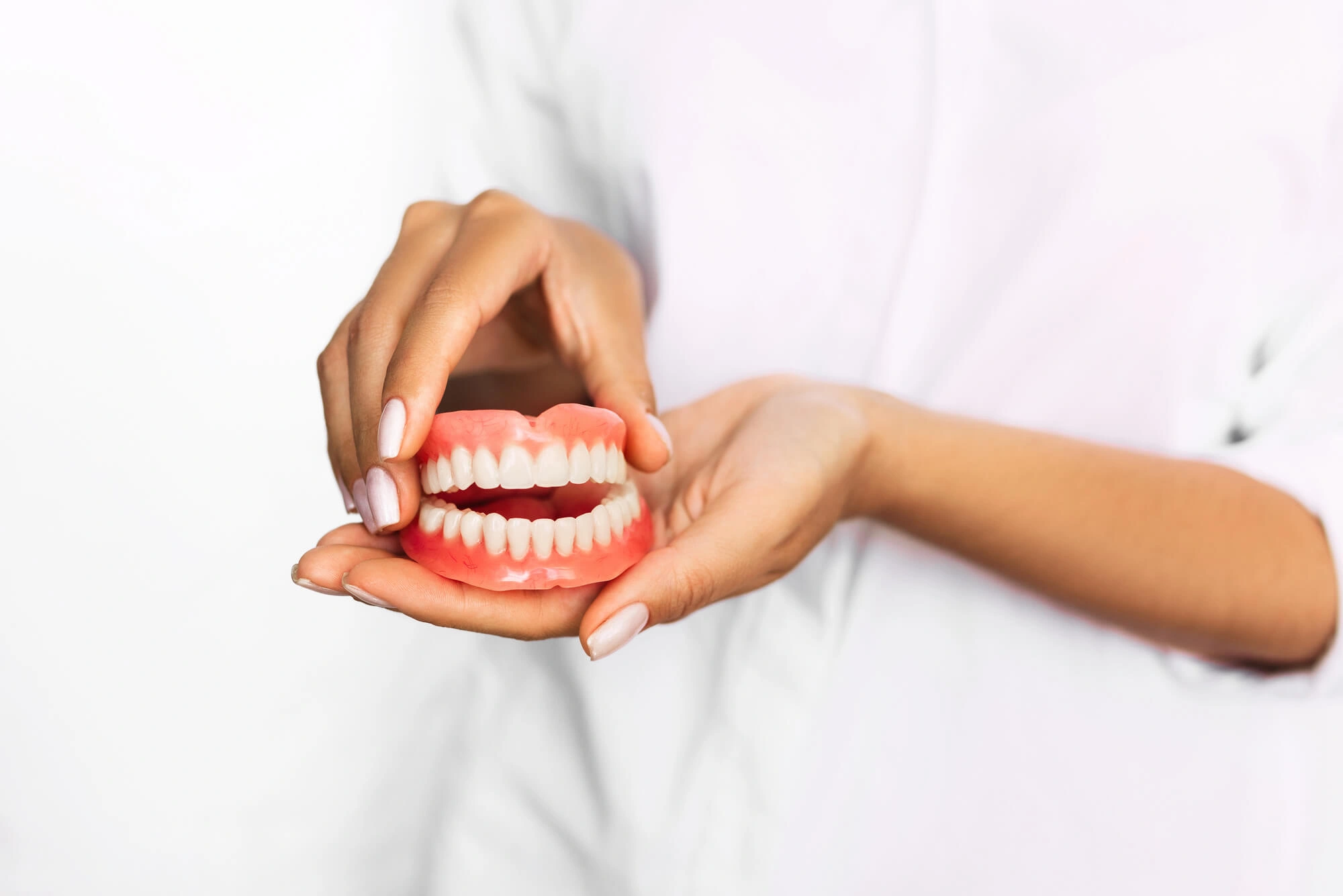 Dentist holding hybrid dentures boca raton